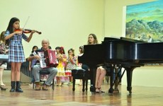 Estudante participando de apresentação do projeto "Musicalização Infantil através do violino e viola". Imagem disponível no SIGAA.