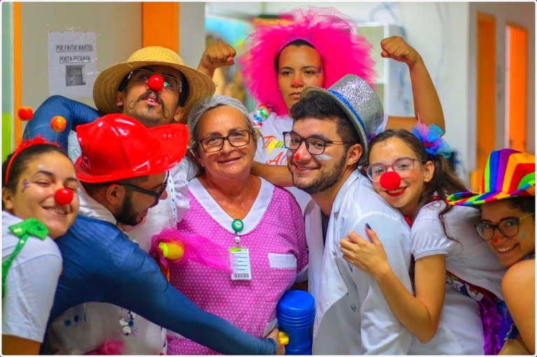 1 Enfermeiros (as) do hospital interagem com os voluntários que brincam e fazem piadas nos corredores do Hospital Universitário, levando alegria a todos, adultos e crianças. Imagem: foto post do projeto no Instagram @tiquinhodealegria