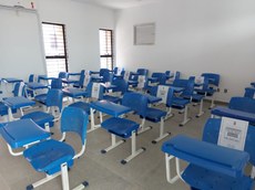 Cadeiras em sala de aula sinalizadas para manter o distanciamento